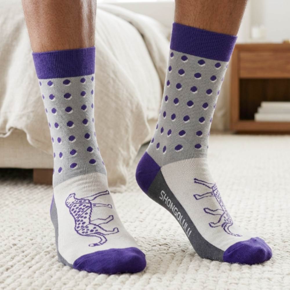 man wearing gray socks with purple accents and cheetah design on a carpeted floor.