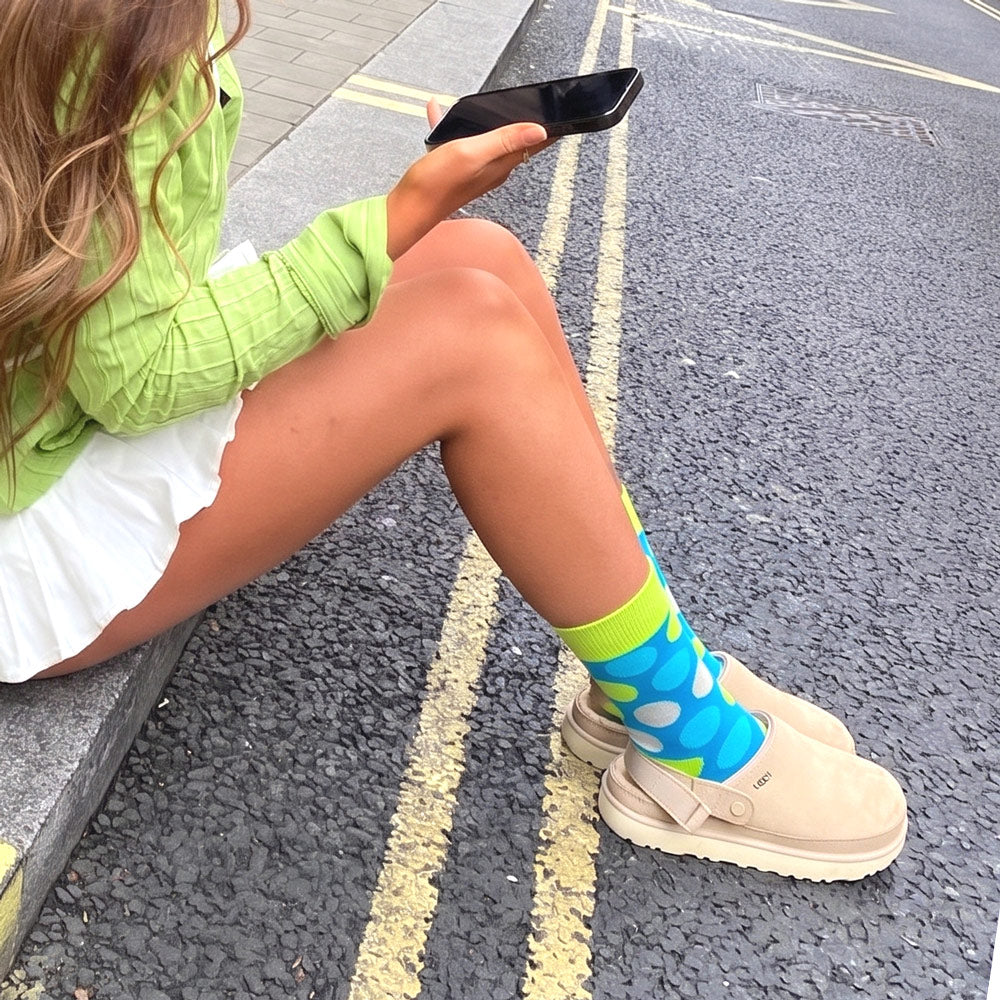 Shongolulu neon green and blue crew sock worn with Uggs