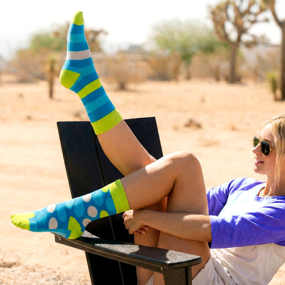 young girl outdoors wearing colorful Shongolulu socks with a desert landscape in the background