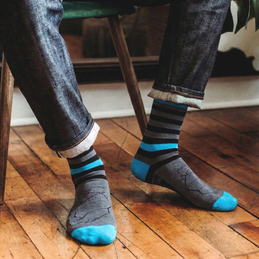 Black blue and grey striped socks with rhino print, paired with denim pants