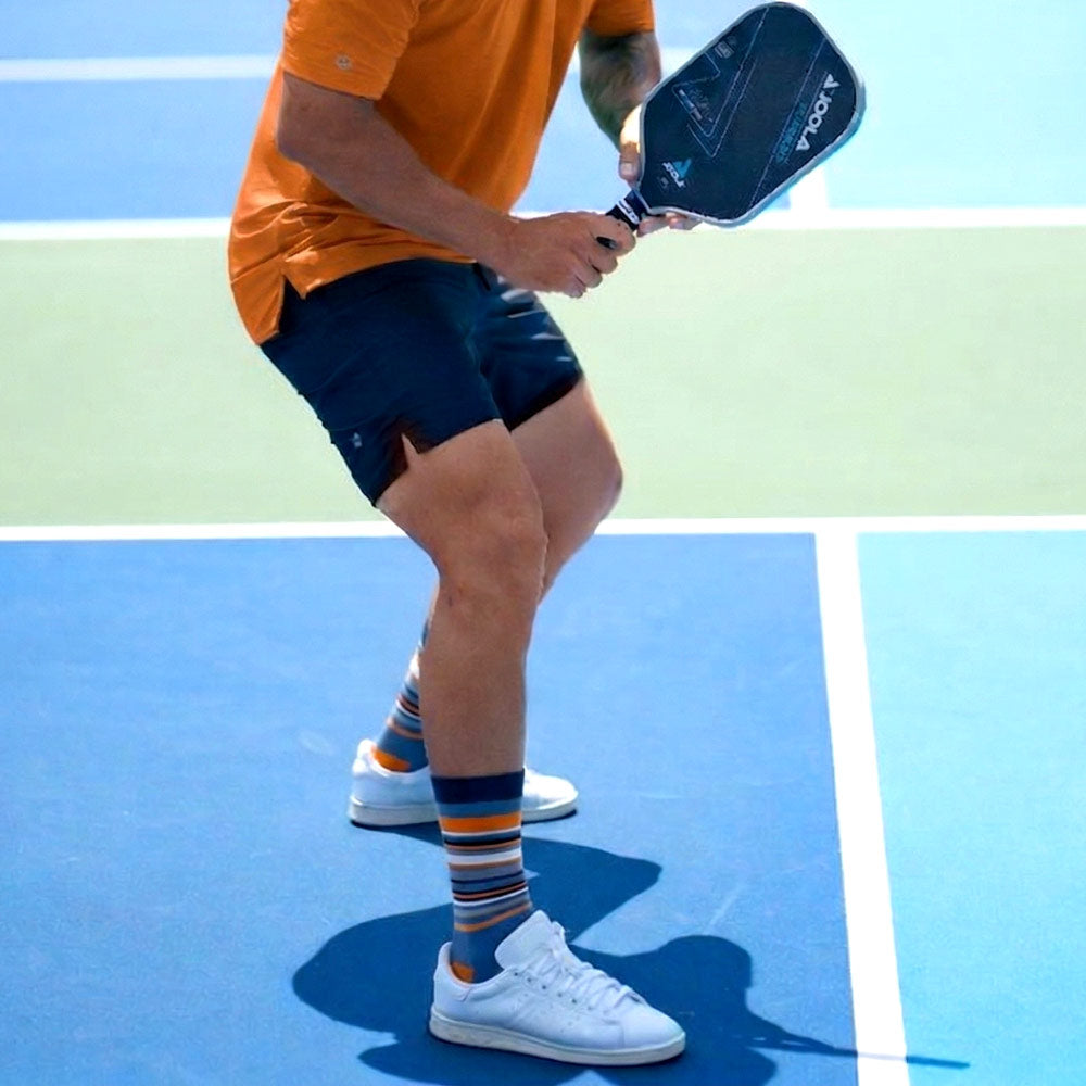 Shongolulu orange blue striped gorilla print socks on pickleball player