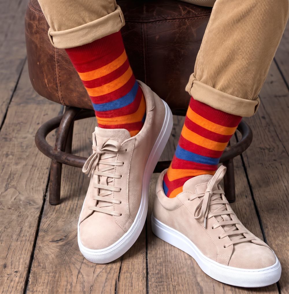 Red orange and blue striped socks with Lion graphic for men, paired with suede sneakers