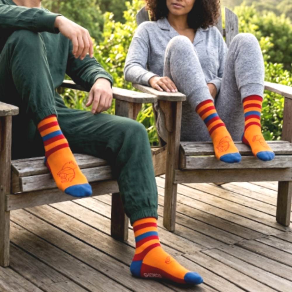 man and woman wearing colorful Shongolulu lion print socks outdoors.