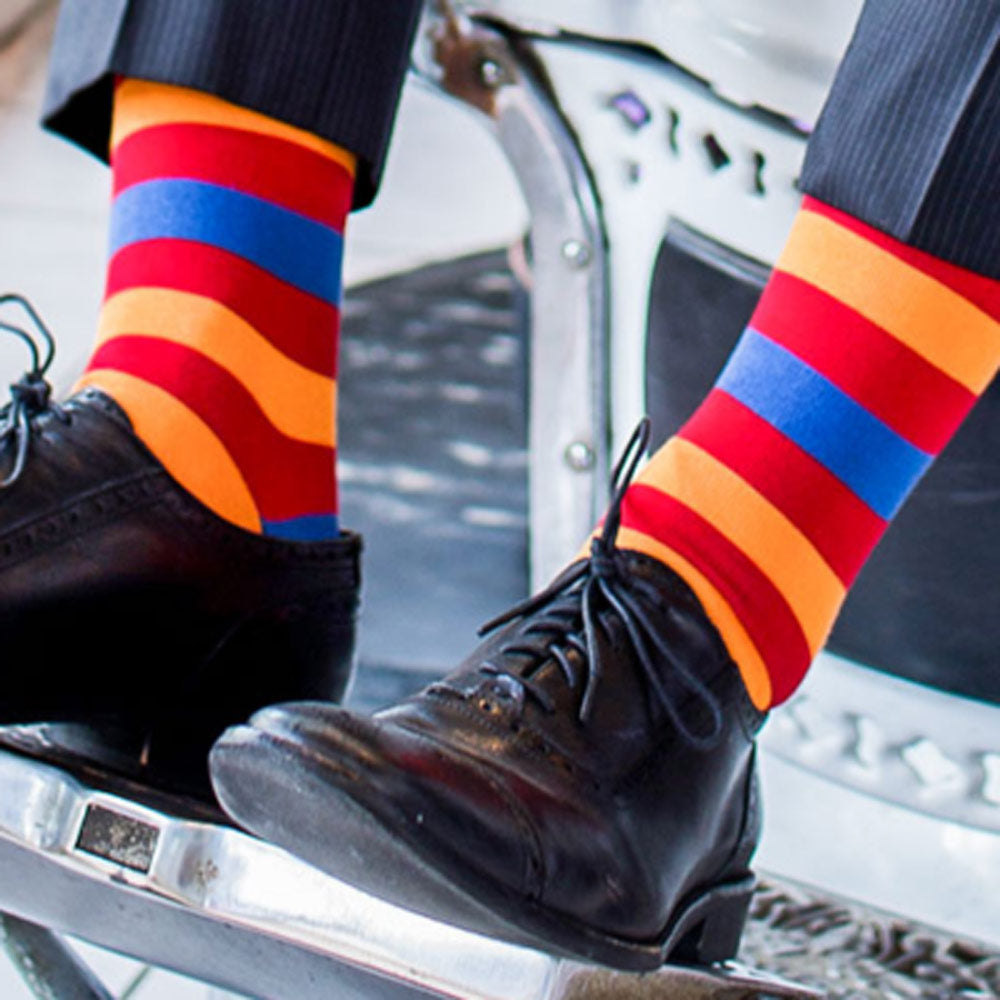 Red orange and blue striped socks with Lion graphic for men worn with black dress shoes
