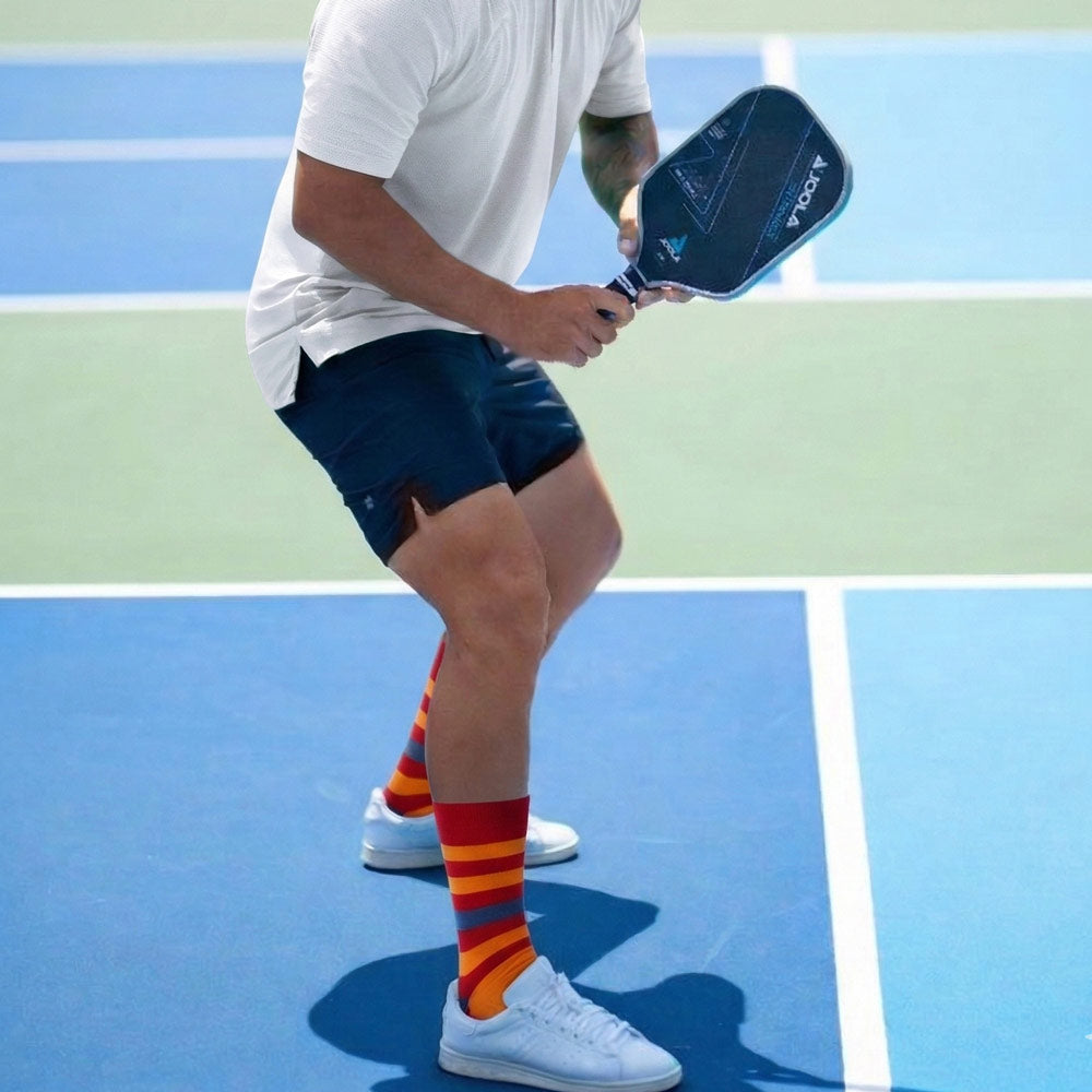 Shongolulu Lion print socks in orange red and blue stripes worn by male picklelball player