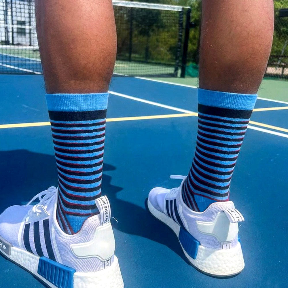 Blue red and black Tiger stripe socks worn at pickleball court